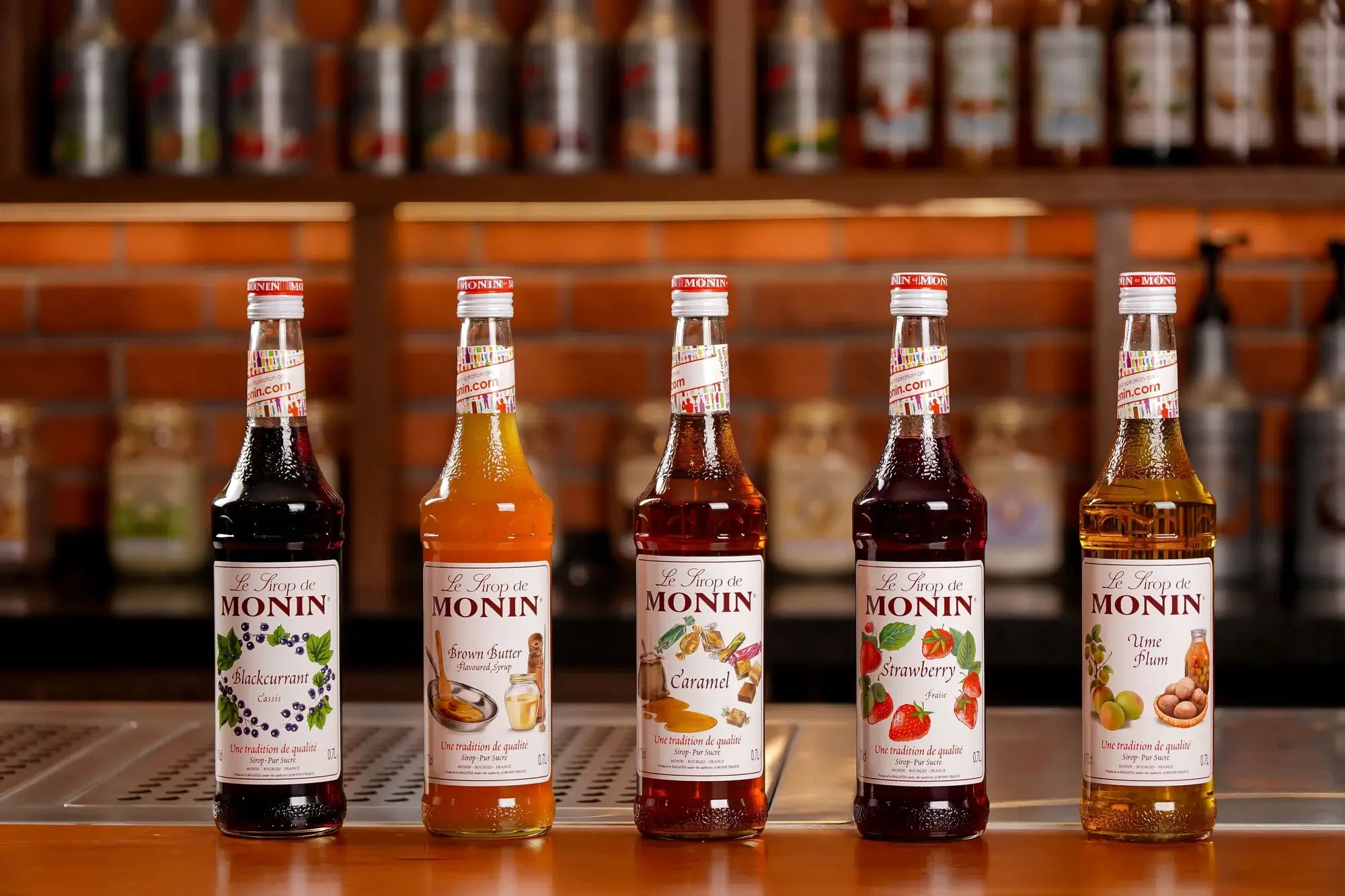 Bottles of Monin syrup displayed on a café’s countertop, highlighting a variety of flavours for coffee, tea, and specialty beverages