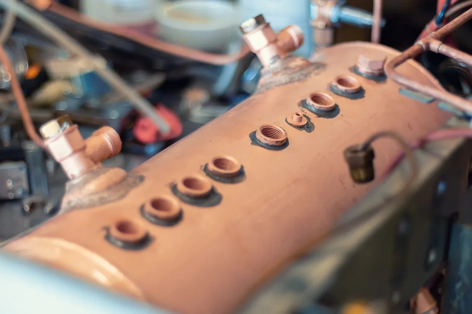 Close-up of a boiler inside a barista coffee machine, showing fittings and components for heat exchanger or multi-boiler comparison